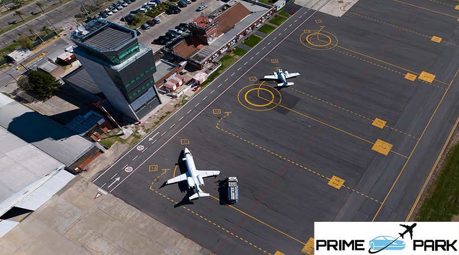 Aerial view of an airport with planes parked on the runway next to the control tower.