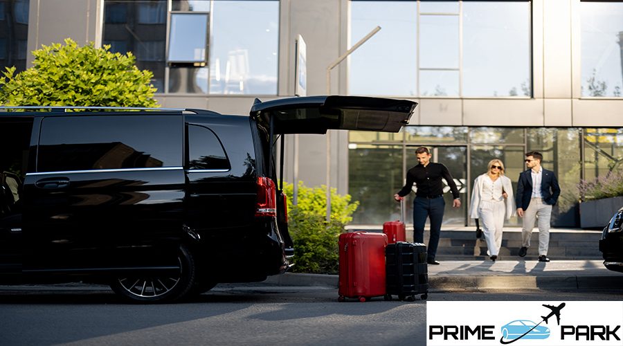 Driver or concierge helps a business couple carry their suitcases to minivan taxi from hotel. Concept of business travel and transportation service