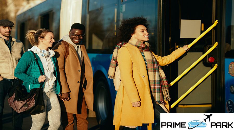 Small group of happy commuters getting in a bus at the station. Focus is on African American woman.