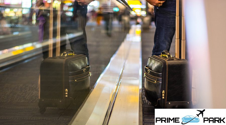 midsection-man-with-luggage-standing-moving-walkway