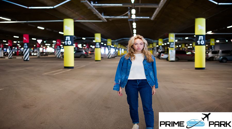 young beautiful woman in jeans clothes in parking of shopping center. portrait of a girl with freckles on her face