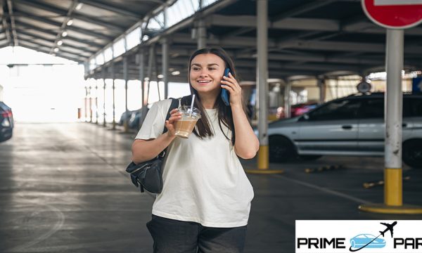 Attractive young woman in a car park with a cup of coffee, lifestyle and travel concept.