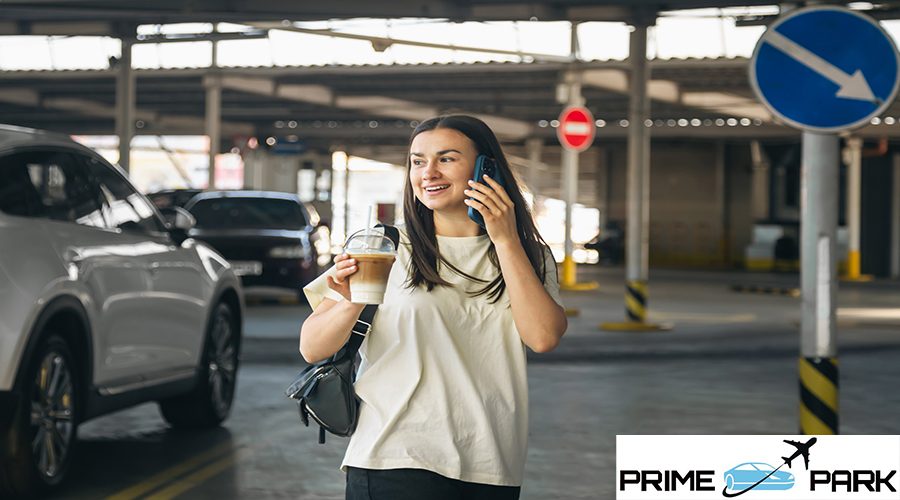Attractive young woman in a car park with a cup of coffee, lifestyle and travel concept.
