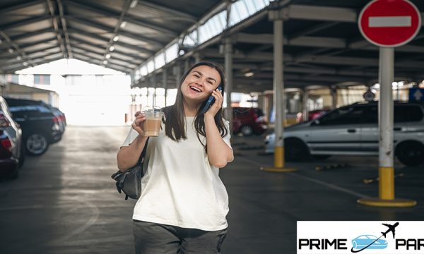 Attractive young woman in a car park with a cup of coffee, lifestyle and travel concept.